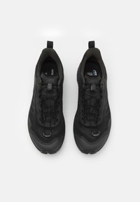 Zwarte sportieve schoenen met een ademende mesh bovenkant, versterkte rubberen zool en elastische veters. Voorzien van een trekband aan de hiel voor gemakkelijke aan- en uittrekken.