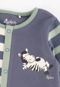 Langärmliges Hemd in Blau und Creme mit Streifen und grünem Ausschnitt; zeigt ein gedrucktes Zebra-Design auf der Vorderseite und Druckknopfverschlüsse.