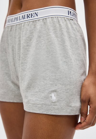 Κοντινή λήψη προσώπου που φοράει ανοιχτό γκρι βαμβακερά σορτς με λευκή ελαστική μέση Ralph Lauren και μικρό κεντημένο λογότυπο στο αριστερό πόδι.