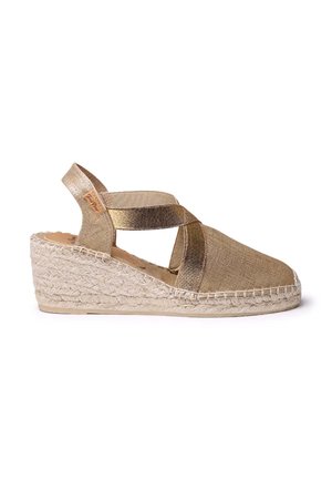 Kuldne kangast vööga espadrill, millel on ristuvad rihmad, tekstureeritud pealmine osa ja jute-kattega tald, millel on naturaalset värvi välistald.
