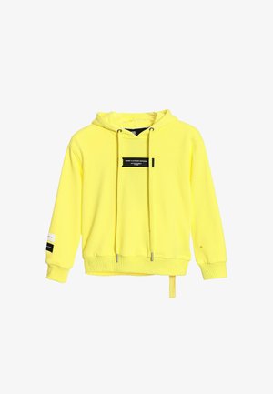 Sudadera amarilla con capucha, parches con logo negro, cordones ajustables, puños y dobladillo acanalados, y detalle de etiqueta lateral. Textura de tela suave.