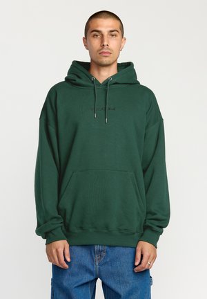 Sudadera verde con bolsillo tipo canguro, capucha con cordón y logotipo grabado "VOLCOM" en el pecho. Fabricada con una tela suave y gruesa. Ajuste casual.