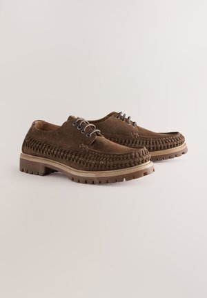 Pantofi din piele întoarsă maro, cu design împletit, închidere cu șiret și talpă groasă din cauciuc cu detalii antiderapante.