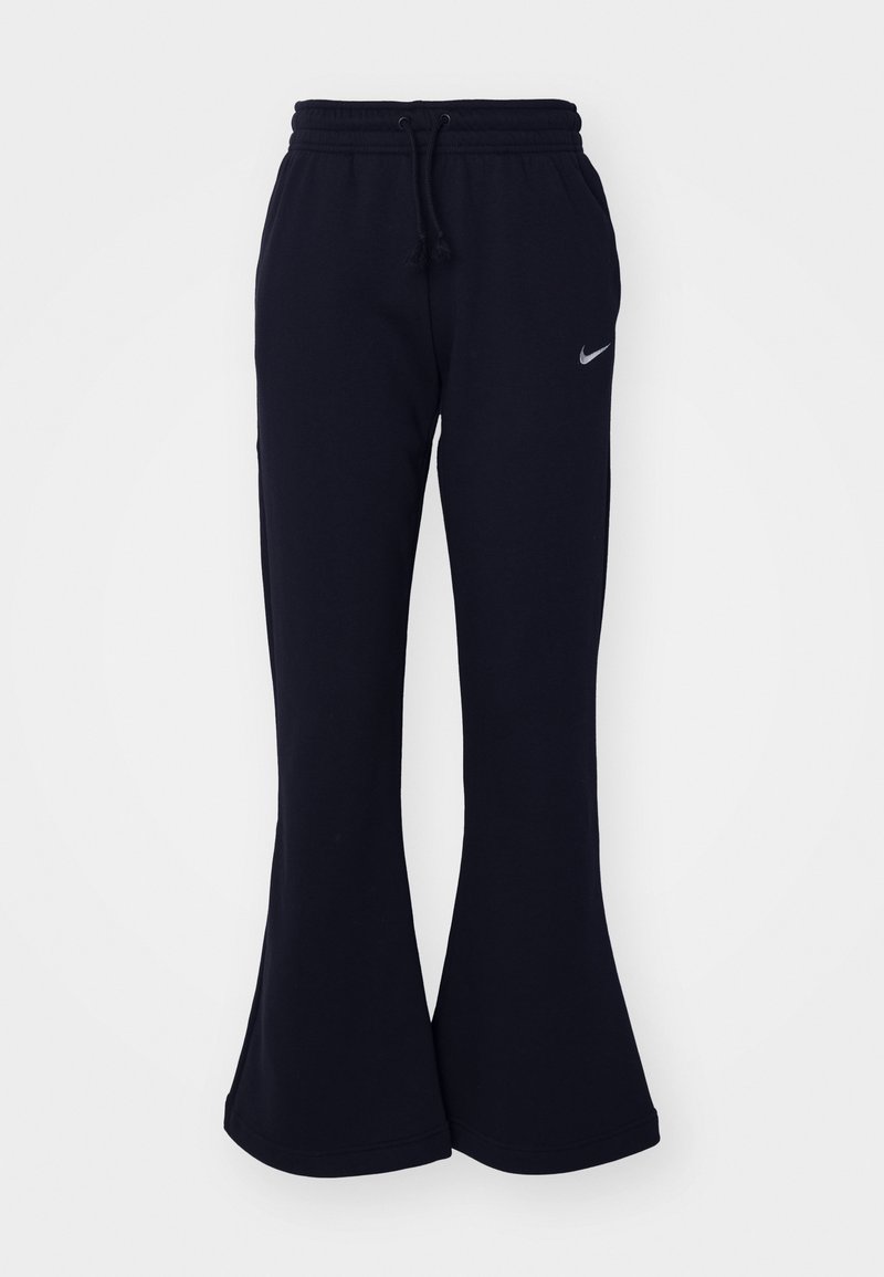 Pantalons de survêtement bleu marine à design évasé, fabriqués en tissu doux, avec une taille élastique et un logo Nike argenté sur le côté gauche.