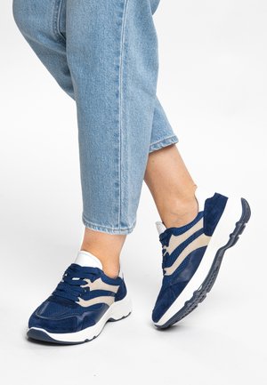 Blue suede and mesh sneakers with white and beige accents, featuring laces, a cushioned sole, and a modern athletic design.