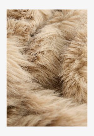 Miękka tkanina z futra syntetycznego w kolorze beżowym, charakteryzująca się puszystą teksturą i długimi włóknami, z różnorodnymi odcieniami i głębokościami w całej powierzchni.