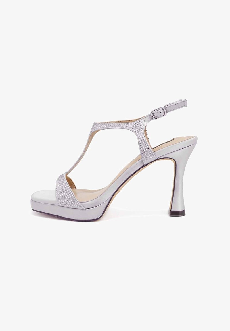 Sandali con tacco alto in argento, design a T-strap, tomaia decorata e fibbia regolabile alla caviglia. Presentano una piattaforma per un'altezza aggiuntiva.
