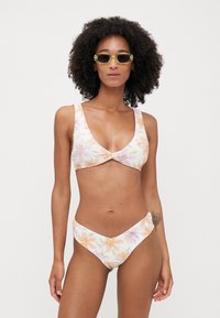 Floral bikini set with a twist front top and low-rise bottoms. Features pastel colors with a textured pattern and wide shoulder straps.
