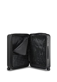 Valise à coque dure noire ouverte montrant des compartiments intérieurs vides avec des séparateurs en mesh zippés et en tissu, posée sur quatre roulettes.