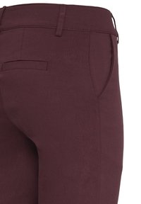 Bordeauxkleurige broek met een gladde textuur, voorzien van een klein achterzakje en een getailleerd ontwerp. De tailleband is gestikt met een stevige naad.