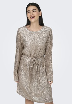 Glittrande beige klänning med långa ärmar, rund halsringning och bälte i midjan. Täckt i reflekterande paljetter, med en avslappnad passform.