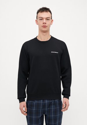 Felpa nera con maniche lunghe, scollatura rotonda e polsini a costine. Presenta un piccolo logo bianco "Emporio Armani" sul petto.