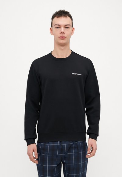 Zwarte sweatshirt met lange mouwen, ronde hals en geribde boorden. Bevat een klein, wit "Emporio Armani" logo op de borst.