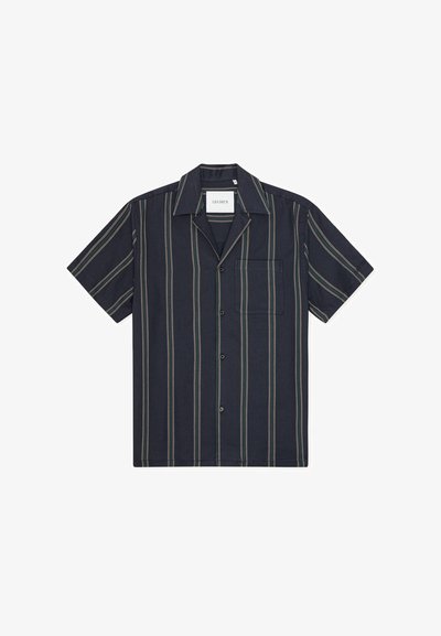Chemise à manches courtes à boutons, en tissu bleu marine foncé avec des rayures verticales vertes, beiges et rouille. Comprend une poche poitrine.