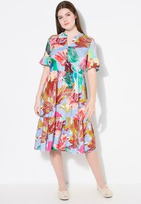 Vestido maxi floral en multicolores con mangas cortas con volantes, escote en V y falda de capas. Hecho de una tela ligera con una textura suave.