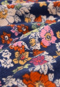 Țesătură bleumarin cu un model floral ce include flori portocalii, roz, galbene și verzi. Textura pare moale, având un design subtil cu nervuri.