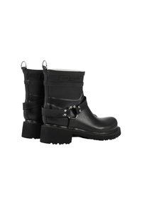 Botas de tobillo de goma negra con un acabado mate, que presentan una correa con herrajes plateados y asas laterales para facilitar su puesta, sobre una suela gruesa.