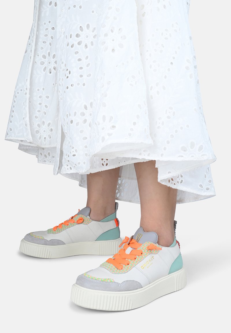 Weiße Low-Top-Sneaker aus einer Kombination von grauem Wildleder und Leder, mit orangen Schnürsenkeln, türkisfarbenen Akzenten und strukturiertem Sohlendesign.