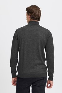 Tmavosivý pulóverový sveter s vysokým golierom, dlhými rukávmi a rebrovanými manžetami. Hladká textúra s jemným vzorom pleteniny.