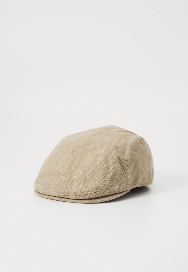 Gorra plana beige hecha de suave tejido de algodón, con forma redondeada, detalles cosidos y una textura lisa.