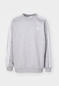 Grå sweatshirt med långa ärmar, vita tre-strimmor på axlarna, rund halsringning, tillverkad av mjukt, texturerat tyg och med en liten logotyp.