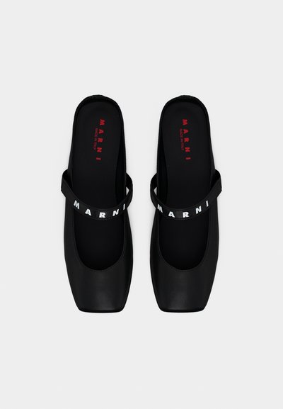Chaussures à talons noirs à bride arrière avec un bout carré, fabriquées en matériau lisse. Elles présentent une sangle avec le lettrage audacieux "MARNI" en blanc.