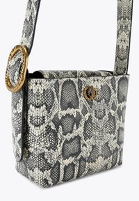 Borsa a mano in pelle sintetica con texture effetto serpente in bianco e nero, con un anello decorativo dorato sulla tracolla e una chiusura a pulsante decorativo.