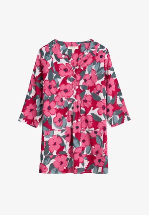 Túnica floral con estampado en rosa y gris sobre fondo blanco, escote en V, detalles de botones y mangas tres cuartos con bolsillos.