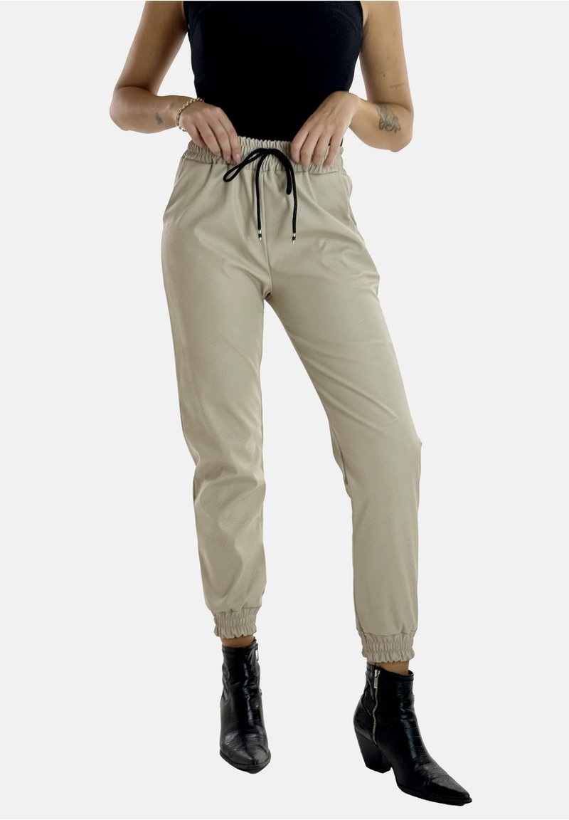 Pantalones jogger beige con cintura elástica y cordón, con puños estrechos, tela suave y ajuste slim.
