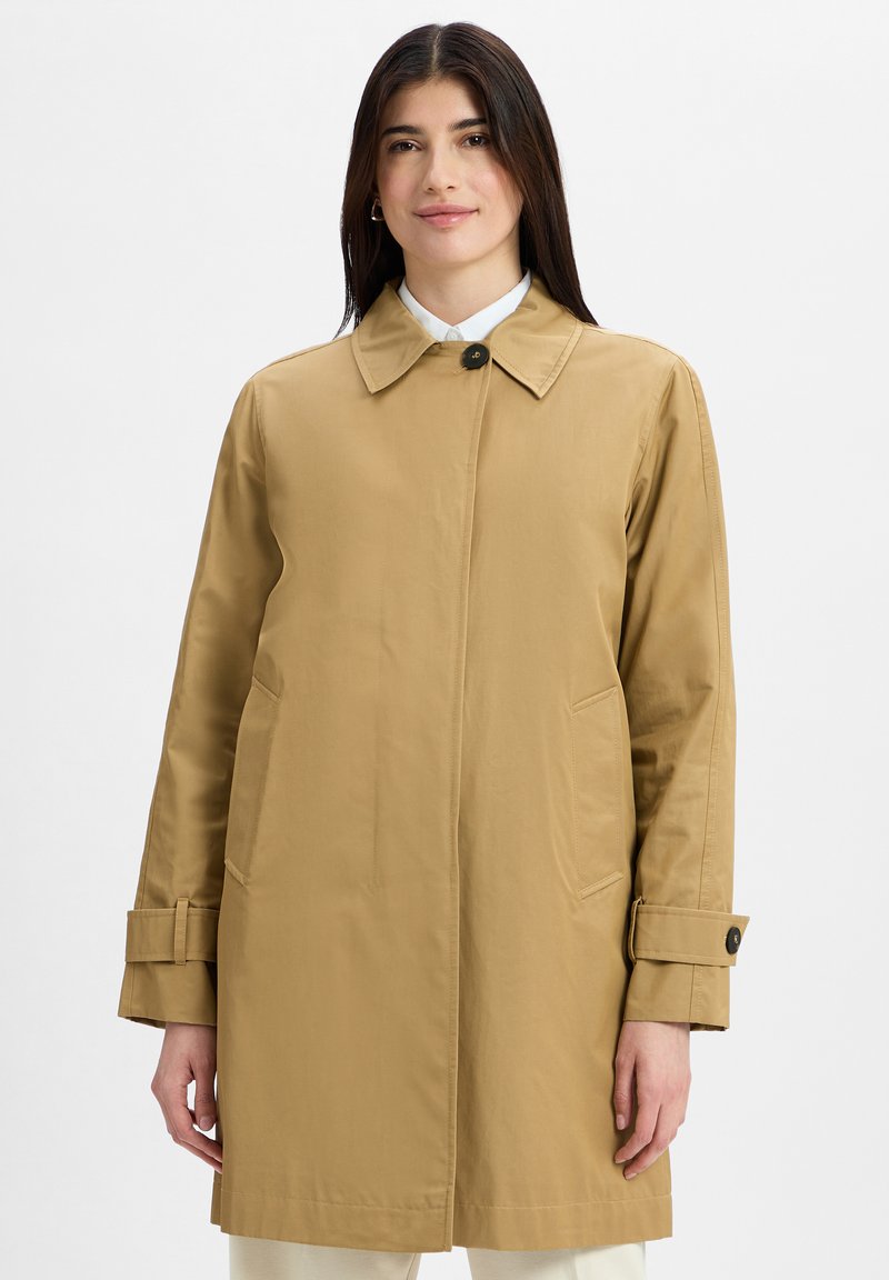 Tan, waterproof trench coat with a collar and a single button closure. Features two side pockets and rolled sleeves. Smooth texture.