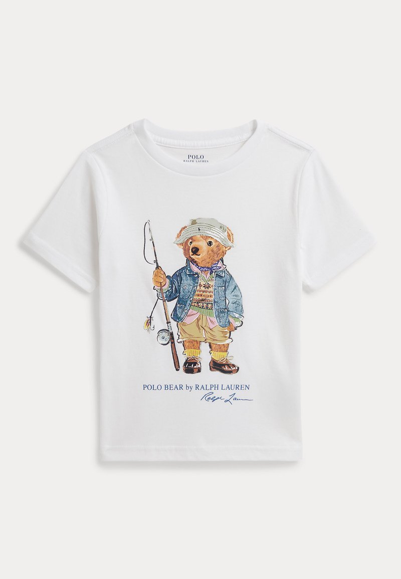 Camiseta blanca con un oso de peluche impreso que lleva equipo de pesca, sostiene una caña de pescar y el texto "Polo Bear by Ralph Lauren" abajo.