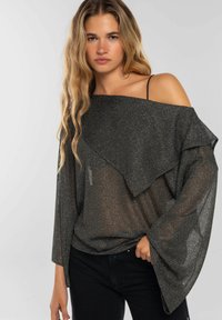 Top transparente negro con un brillo metálico, diseño off-the-shoulder y mangas drapeadas. Tejido texturizado con un ajuste suelto.