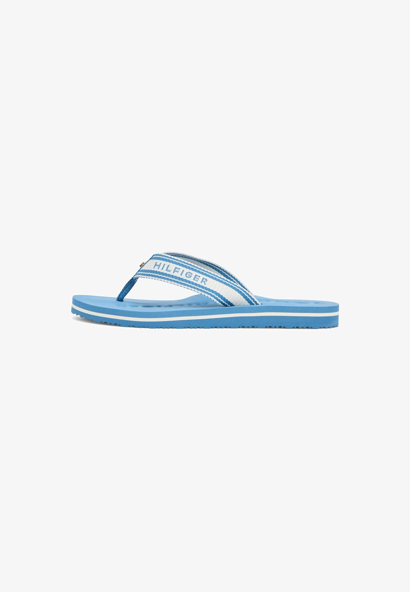 Light blue and white flip-flop sandal with textured sole and fabric strap featuring the "Hilfiger" logo in blue letters.