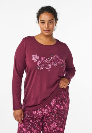 Maroon long-sleeve top with floral print in pink shades across the chest, paired with matching floral pants in similar colors and patterns.