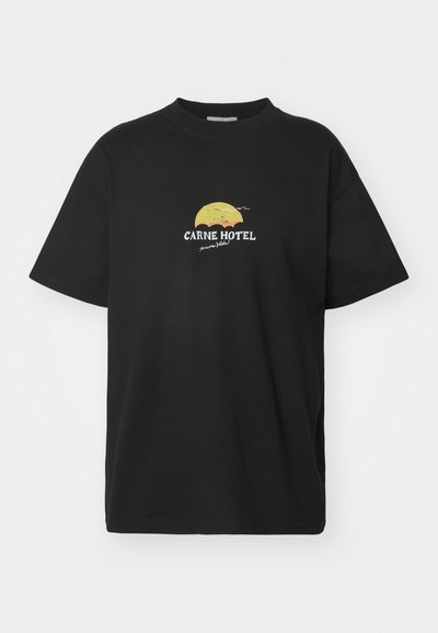 Sort bomulds t-shirt med rund hals, der har et gult solnedgangsdesign og hvid tekst, der står "CARNE HOTEL" på fronten.