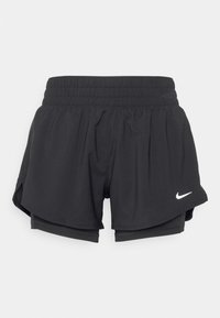 Schwarze Sportshorts mit elastischem Bund, ausgestattet mit einem Lagen-Design und seitlichen Schlitzen. Mit einem weißen Nike-Logo auf der Vorderseite.