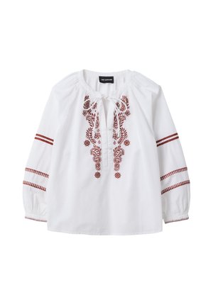 Blusa blanca holgada de mangas largas, con bordado floral marrón en la parte delantera y rayas en las mangas, con un lazo en el escote.