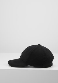 Boné preto de baseball feito de algodão, com uma aba curva, coroa redonda e um pequeno detalhe de logotipo na frente. Textura suave, design clássico.