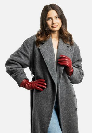 Grau Wollmantel mit großen Revers, doppelt geknöpft und langen Ärmeln. Kombiniert mit roten Lederhandschuhen und hellblauen Jeans.