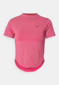 T-shirt de sport rose à manches courtes avec un col rond, présentant un motif texturé sur le devant et un logo Nike en noir.