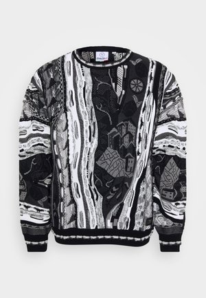 Zwart-wit trui met complexe patronen, zoals stadsgezichten en abstracte ontwerpen. Gebreide textuur met geribde manchetten en halslijn.