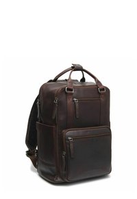 Zaino in pelle marrone con numerose tasche con zip, una maniglia superiore e spallacci imbottiti. Presenta una texture liscia e un design strutturato.