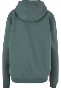 Hooded krekls bālā tirkīza krāsā, izgatavots no mīksta auduma. Ir brīvi pielāgota piegriezuma, riboti piedurkņu gali un apakšmala. Gluda tekstūra bez redzamām rakstām.