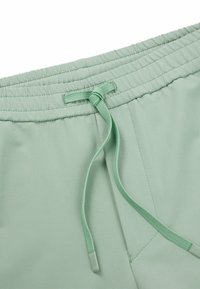 Lichtgroene sportshorts met een elastische tailleband en bijpassend trekkoord, een gladde textuur en zijnaadaccenten.