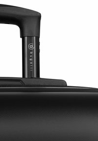 Maleta rígida negra con mango retráctil, que presenta una superficie texturizada y un detalle de logo. Diseño simple y funcional para viajar.