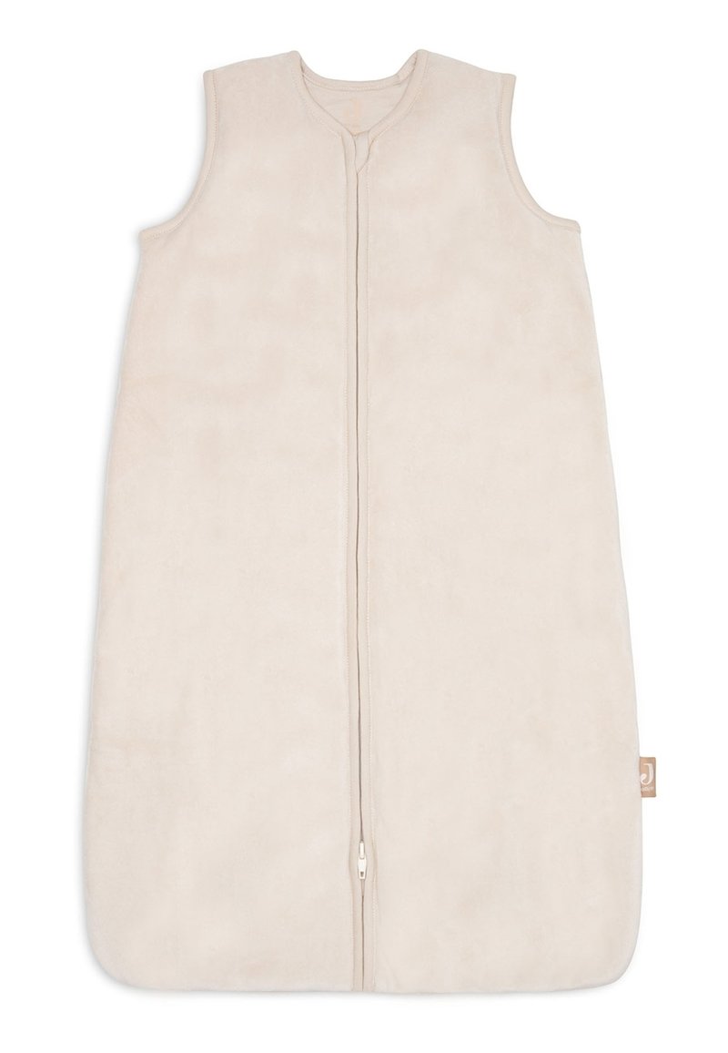 Sac de couchage pour bébé sans manches, beige, avec fermeture éclair, fond arrondi et petite étiquette de marque en tissu sur le côté.