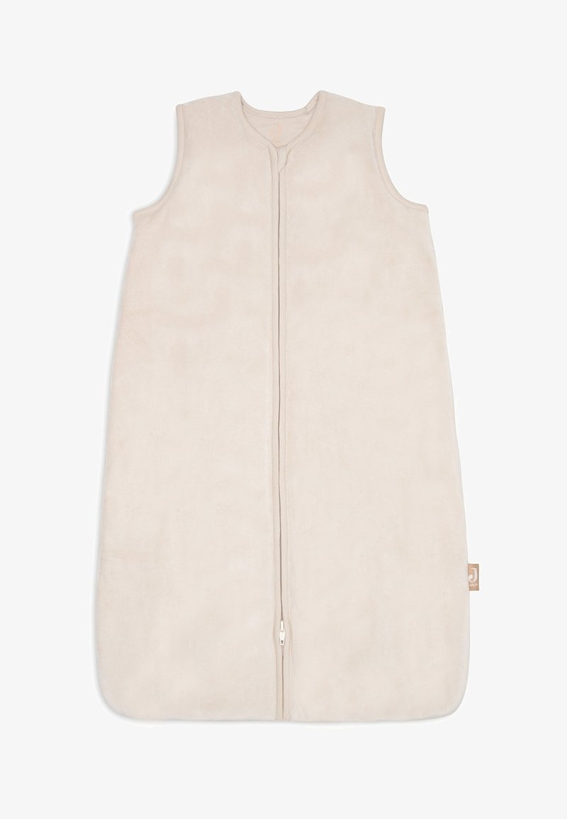 Sac de couchage pour bébé sans manches, beige, avec fermeture éclair, fond arrondi et petite étiquette de marque en tissu sur le côté.