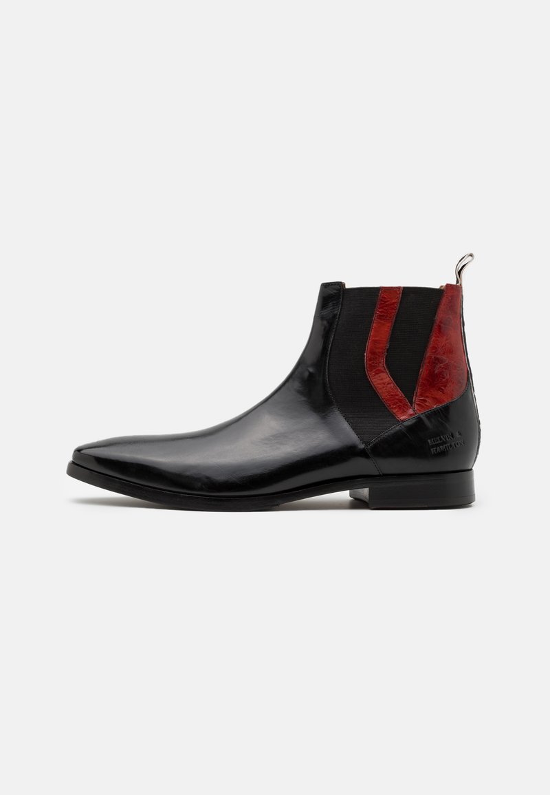 Bottine en cuir noir avec bout pointu, panneaux latéraux élastiques, accents en cuir rouge et languette de tirage sur fond uni.