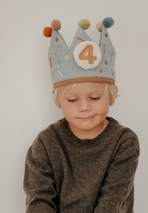 Modrá látková koruna s farebnými brmbolcami a vzorom konfiet. Na kruhovej nášivke je vyšité číslo "4". Hnedý lem na spodku.