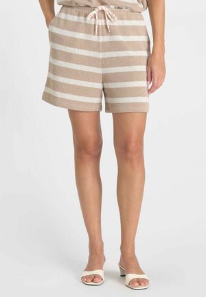 Pantaloncini a righe orizzontali beige e bianche in maglia con vita a coulisse indossati con sandali bianchi con tacco e punta aperta.